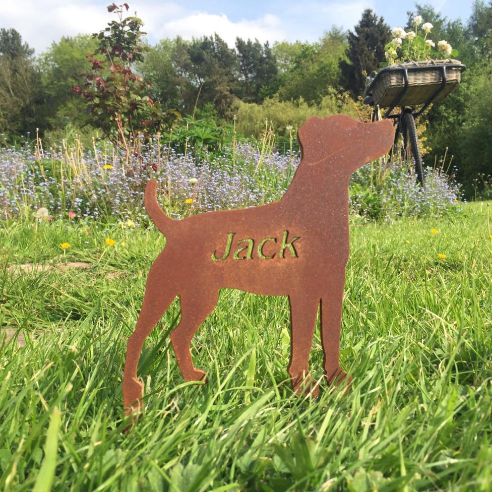A hand-cut steel memorial marker engraved with the name Jack, in a garden